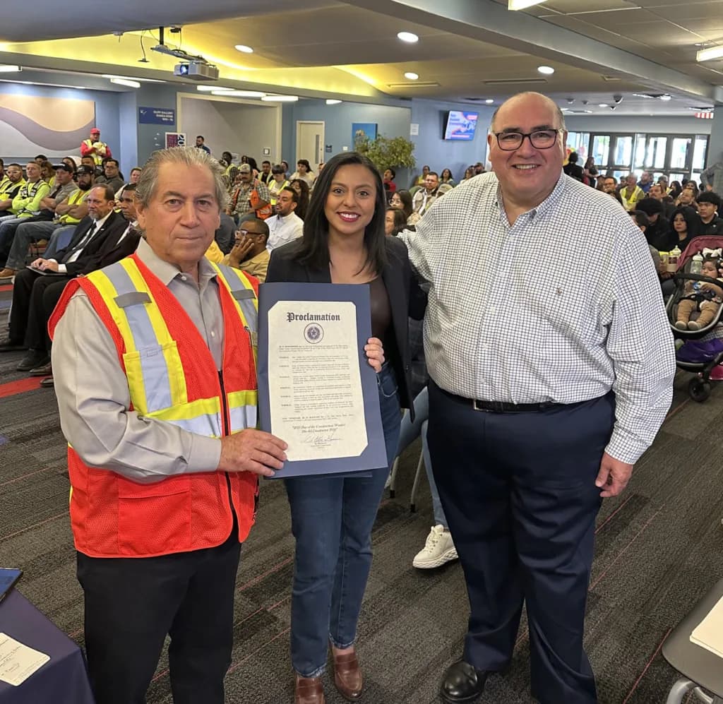 A construction worker receives a proclamation on the Day of the Construction Worker.
