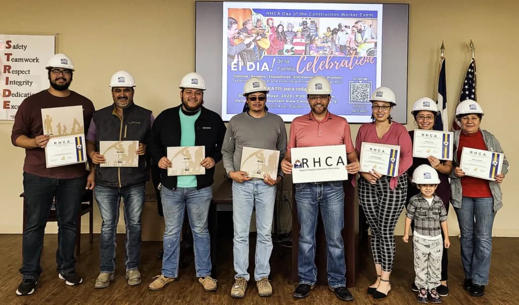 Workers in hard hats holding RHCA certificates at the Day of the Construction Worker