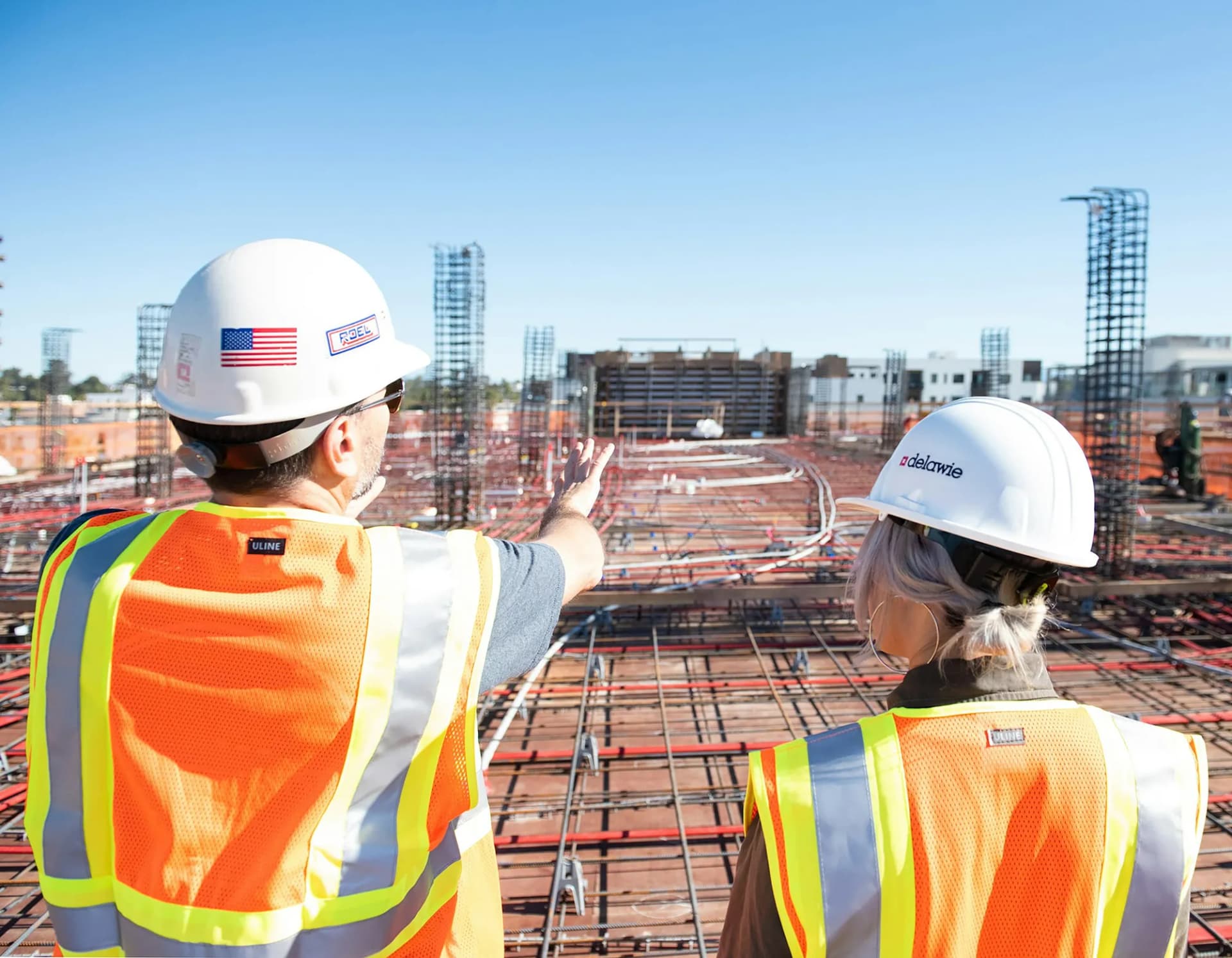 Two construction workers in safety vests at a job site